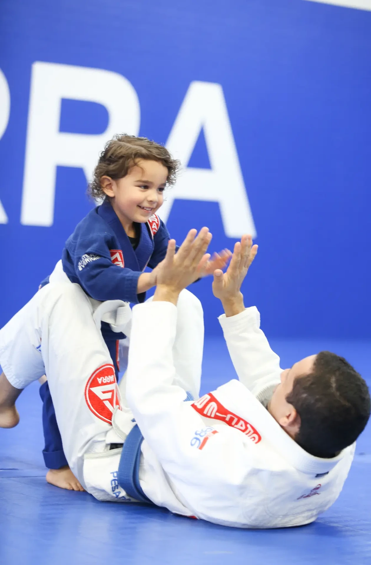 Criança e instrutor treinando Jiu-Jitsu na Gracie Barra Parque das Nações